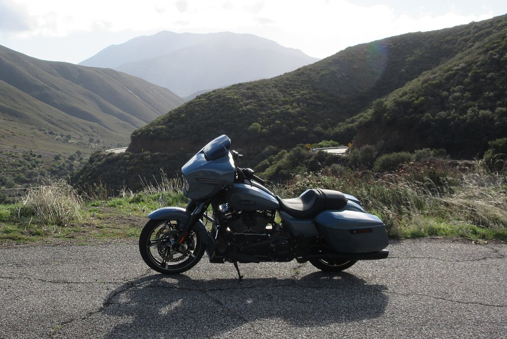 Street Glide parked on a mountain road with curves in the distance