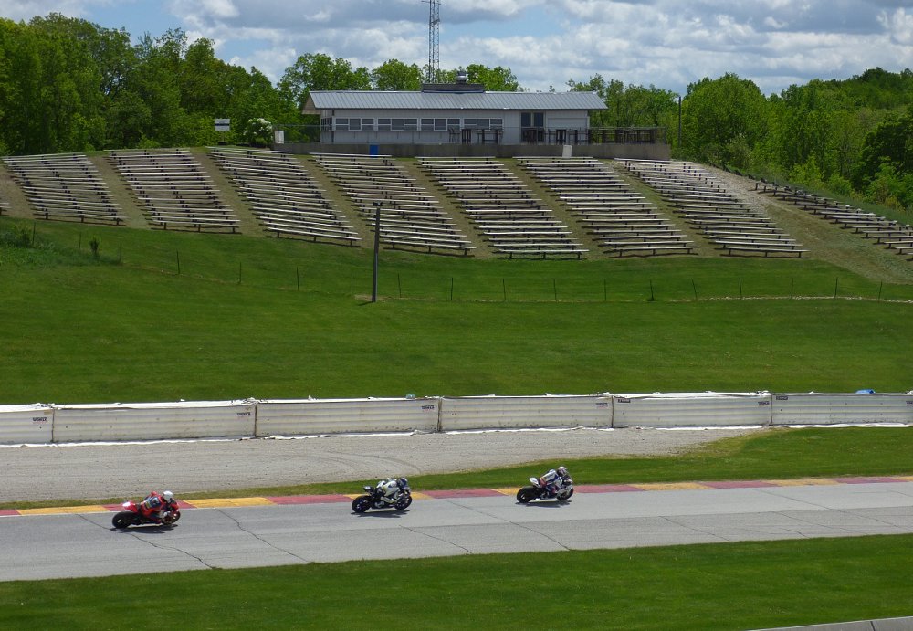 race motorcycles on track in front of empty spectator stands
