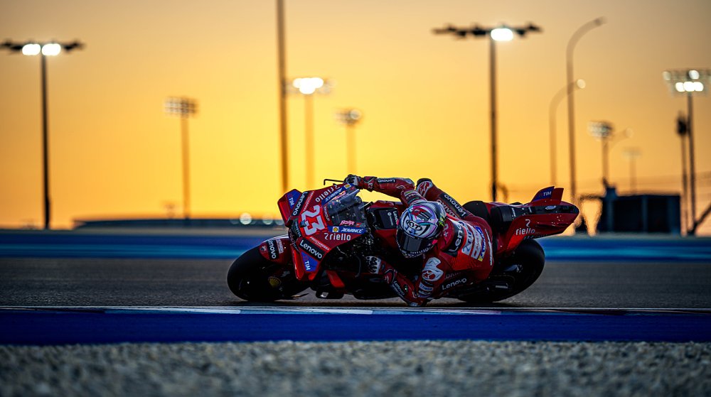 Enea Bastianini on the track in front of a desert sunset