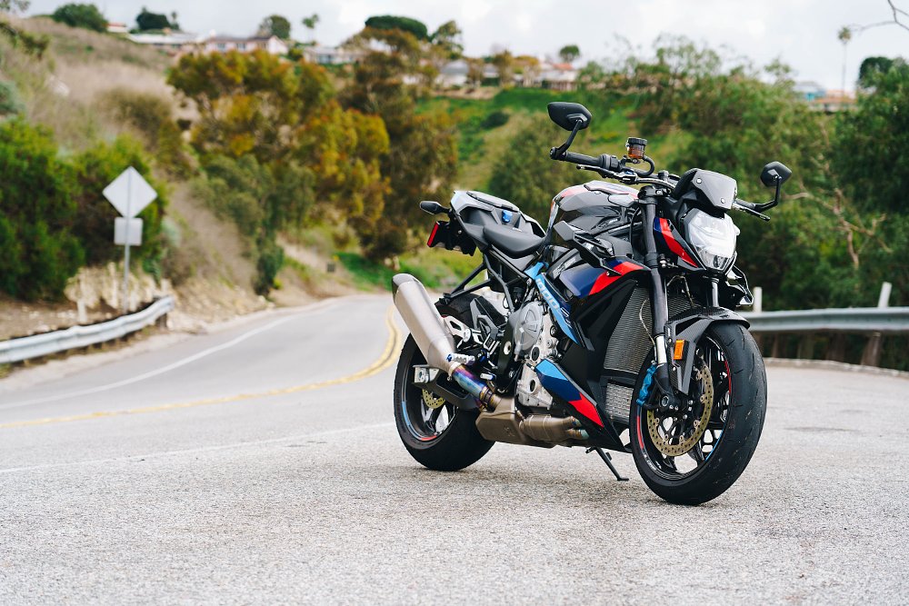 2023 BMW M 1000 R parked next to a twisty mountain road.