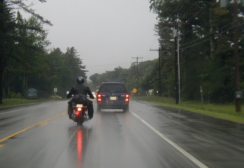 motorcycle and a car in the rain