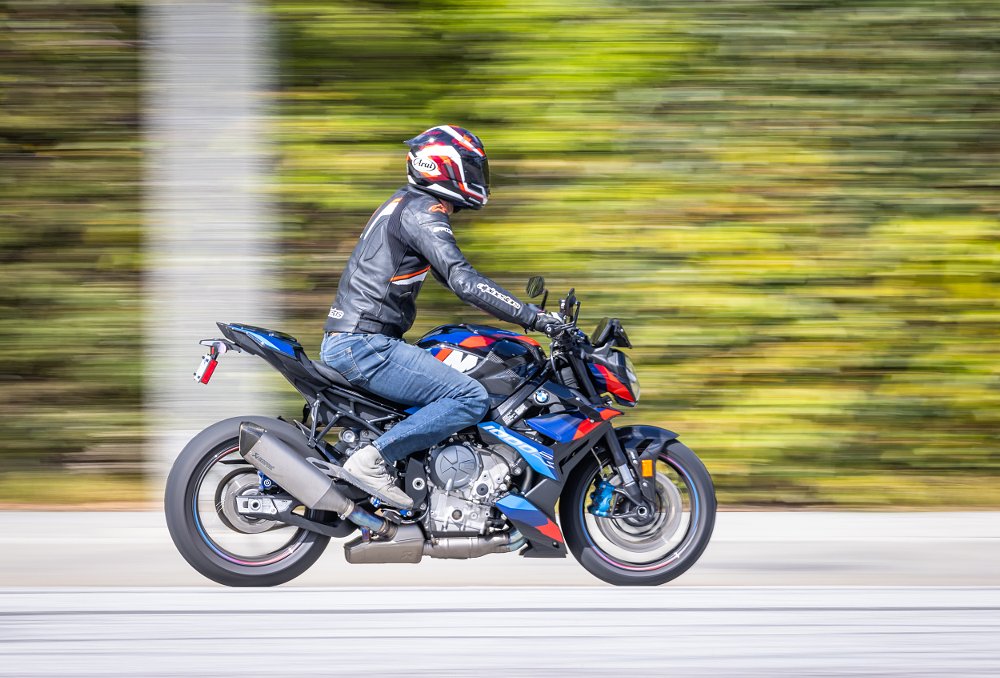 2023 BMW M 1000 R from the right, riding down a city street.