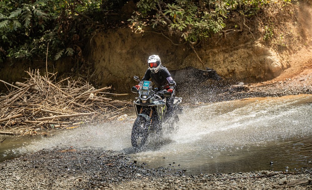 riding the Ibex 450 on a dirt trail through a water crossing