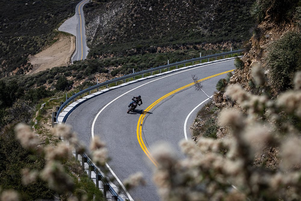 2024 KTM 890 SMT riding along an empty mountain road.