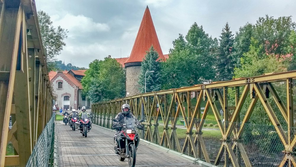 riders crossing a wooden bridge in Europe