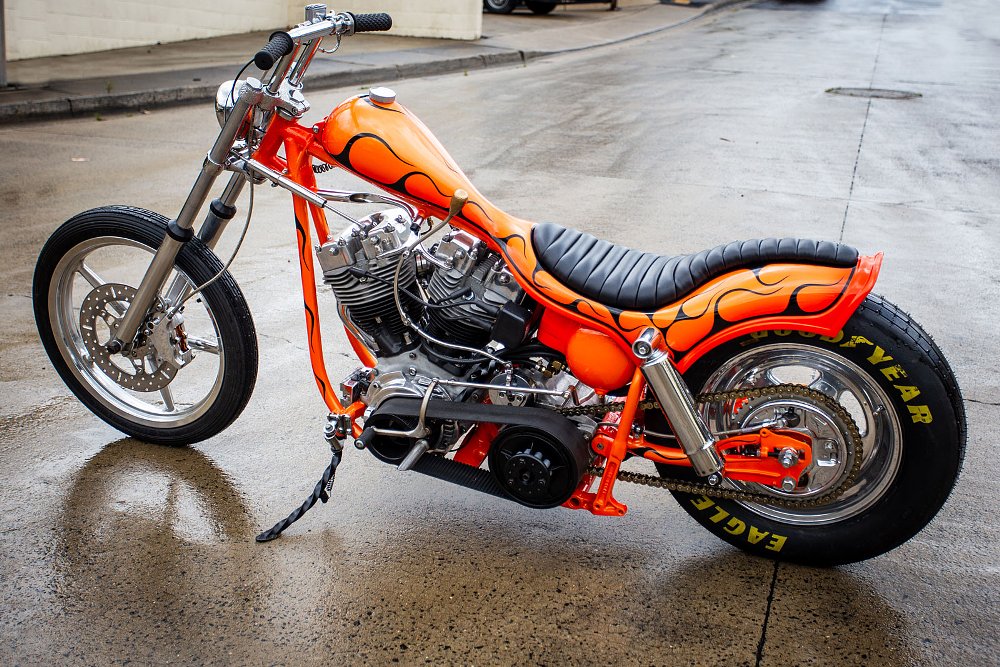 side view of the custom shovelhead in orange paint with black flames