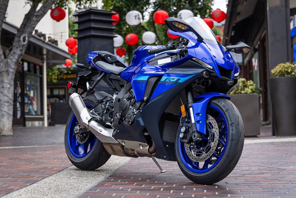 A Yamaha R1 parked in a courtyard with Japanese lanterns hanging in the background.