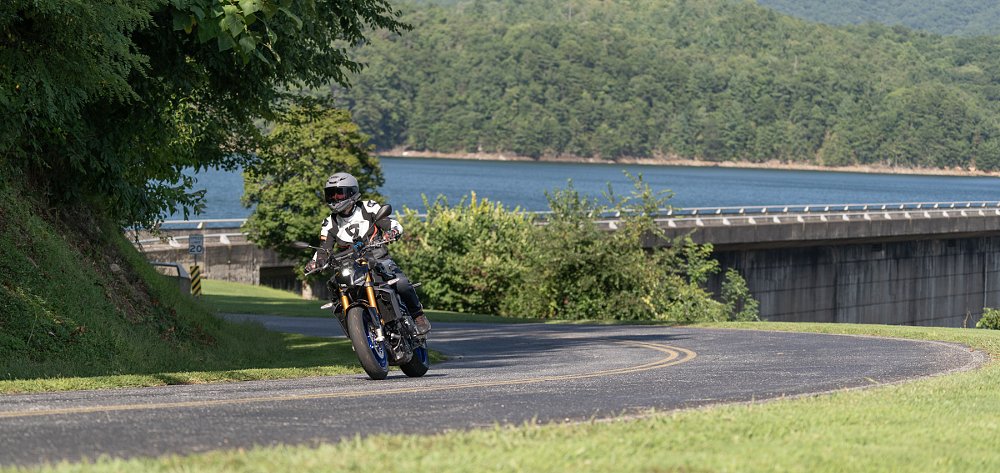 riding the MT-09 SP through a forest by a lake