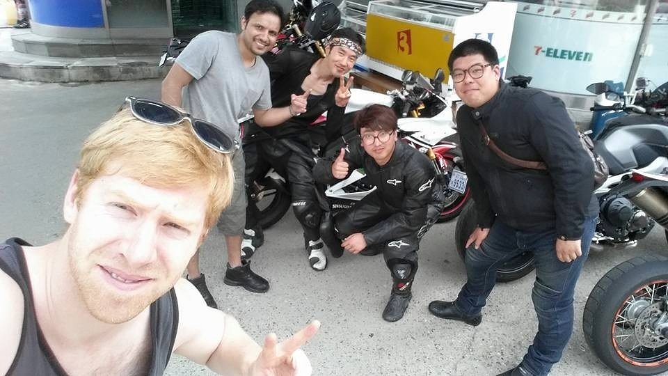 riders smiling for the a selfie around their motorcycles