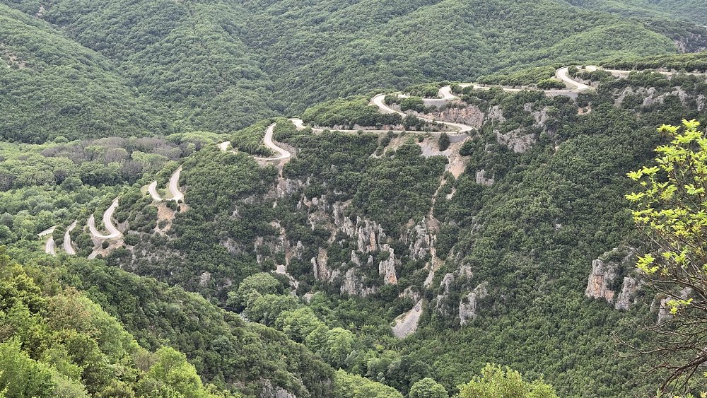 view from above of mountain road with many hairpin turns