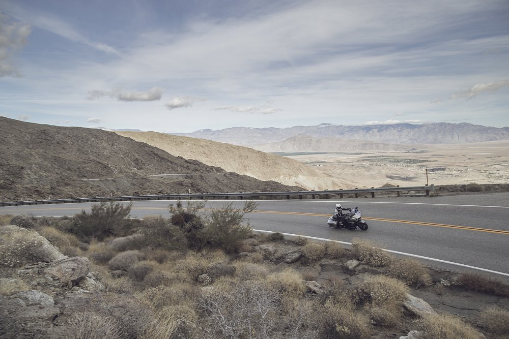 long view of a white Yamaha Eluder traveling desert mountain roads