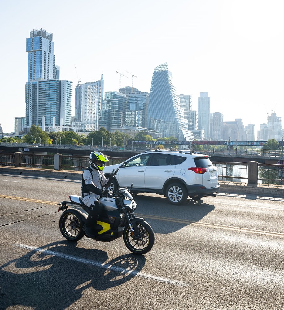 riding the Can-Am Pulse on a city highway with the Austin skyline in the distance