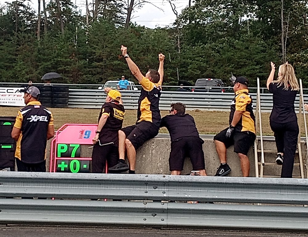 team member in uniform standing by the finish line cheering