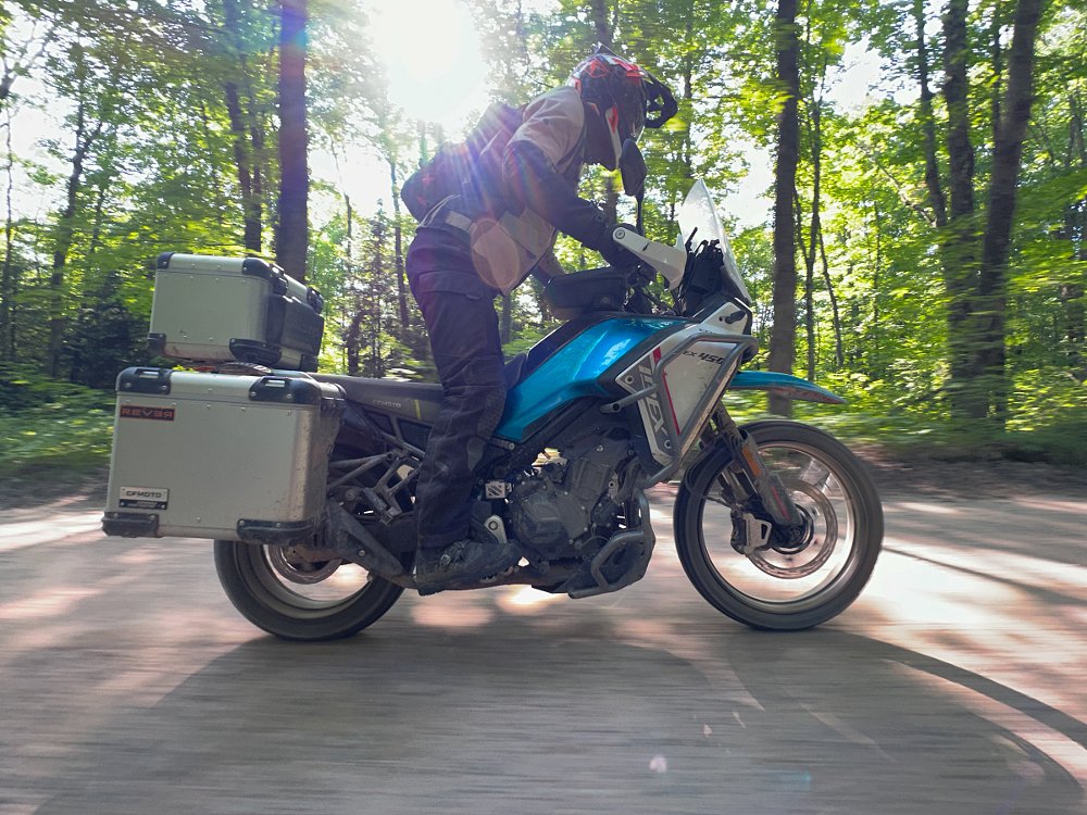rider on a CFMOTO Ibex 450 in the woods 
