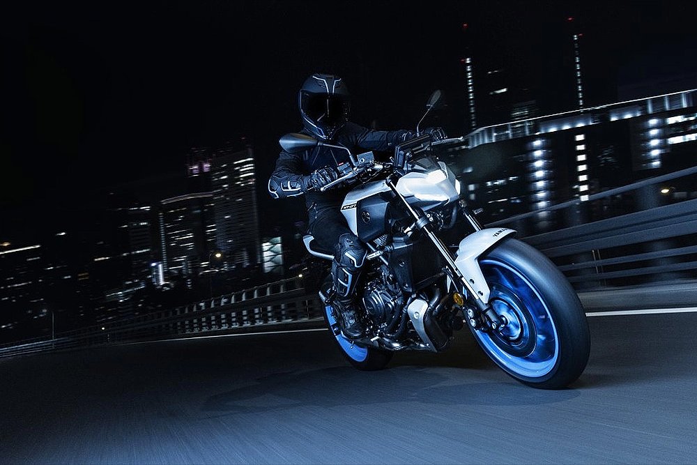 The 2025 Yamaha MT-09 rides through an urban landscape at night.