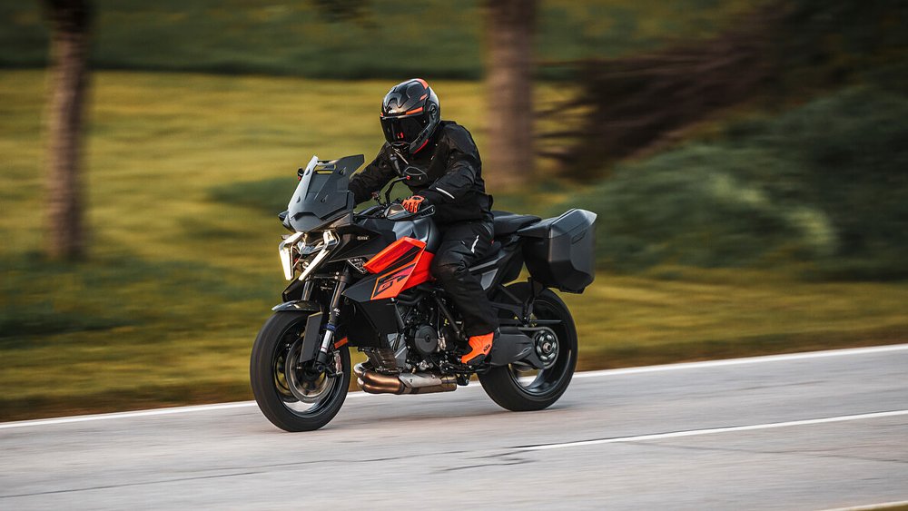 A rider tours a country road aboard the 2025 KTM 1390 Super Duke GT.