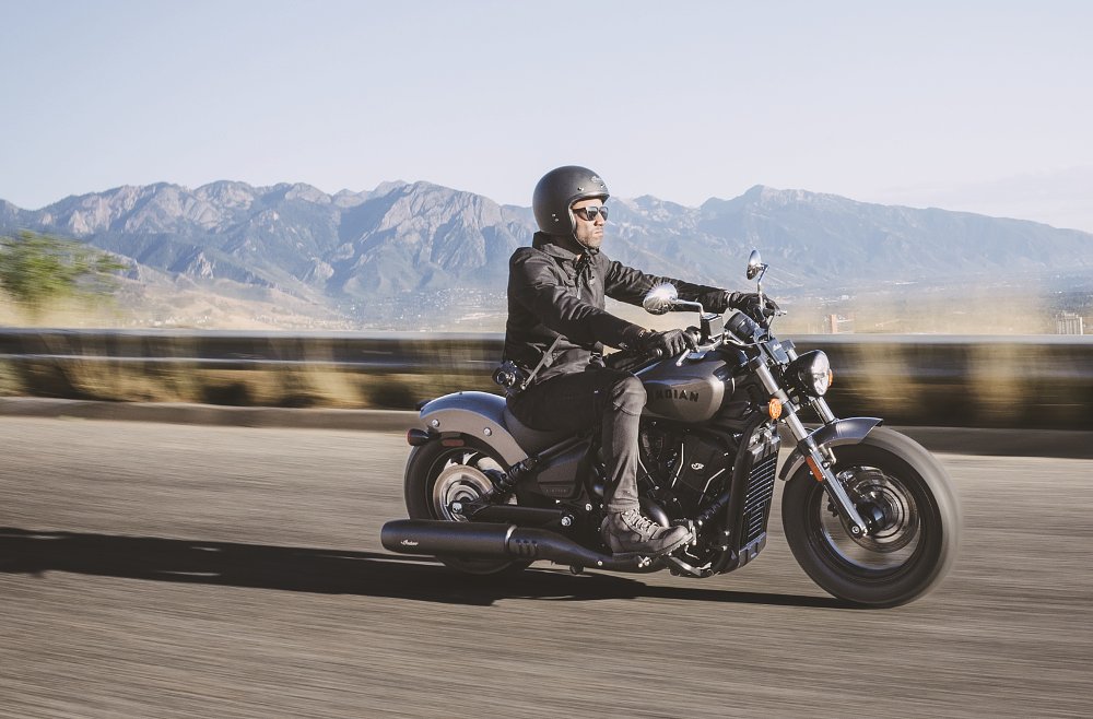 rider on the road on a black Scout Bobber with mountains in the background