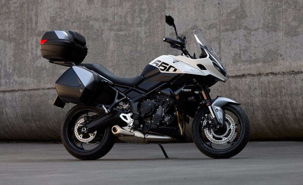 white Tiger Sport 660 fitted with panniers and a large top box with matching color panels