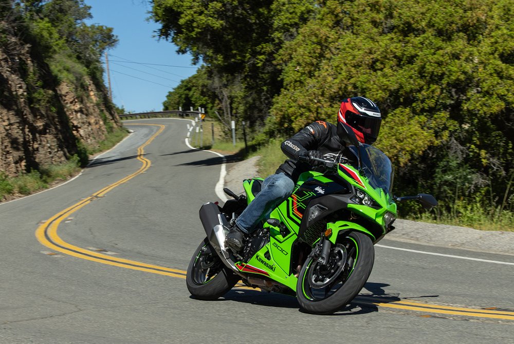 2024 Kawasaki Ninja 500 SE riding toward camera through a curve on a mountain road.
