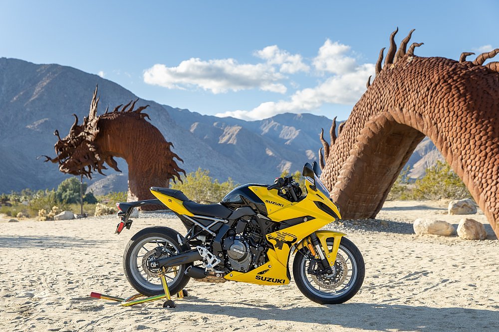 yellow Suzuki GSX-8R in front of a dragon statue in the desert