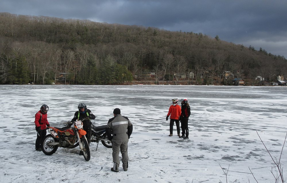 our group standing on the ice at the edge of the lake with the motorcycles, ready to ride