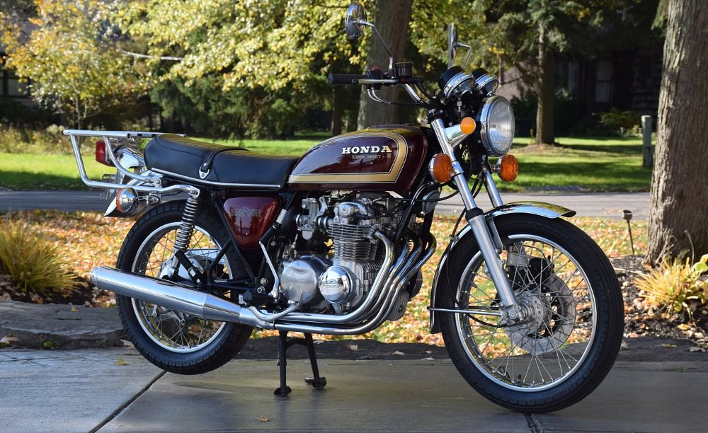 Honda CB550F with four-cylinder engine parked in front of greenery