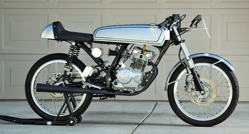side view of the small race bike, with long narrow tank painted silver