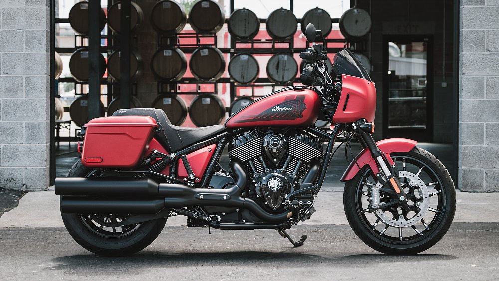 A side profile shot of the 2025 Indian Sport Chief RT with whiskey barrels in the background.
