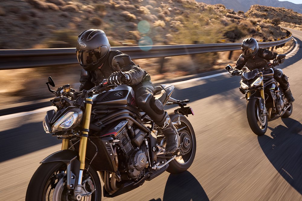 Two Speed Triple 1200 RS riders attack corners on a canyon road.