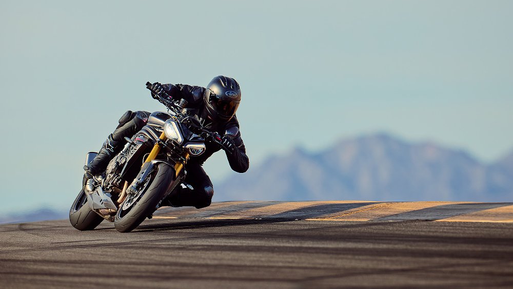 A Speed Triple rider hits an apex on track.