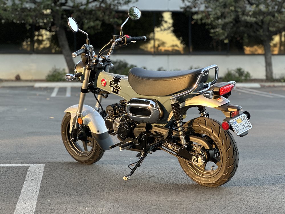 2025 Honda Dax 125 parked in front of an office building.