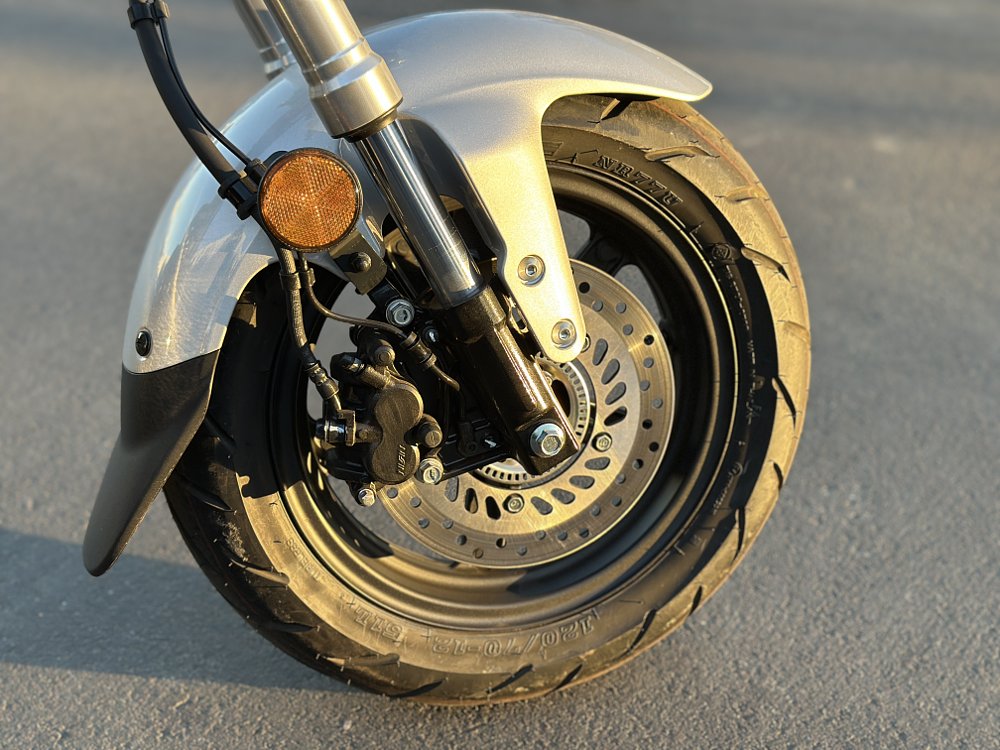 Detail of the front wheel and brake on a 2025 Honda Dax 125.