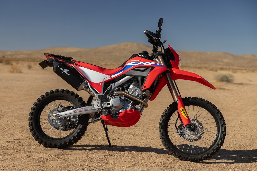 Ari's 2021 Honda CRF300L parked in the desert with mountains in the background.
