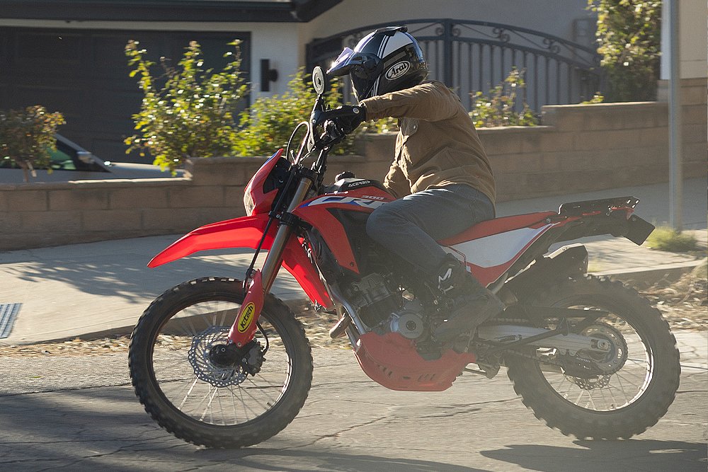 Dustin rides Ari's CRF300L through suburban streets.