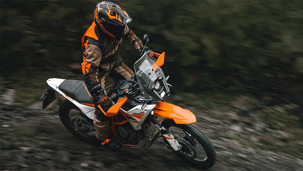 A 390 Adventure R rider navigating a trail in the rain.