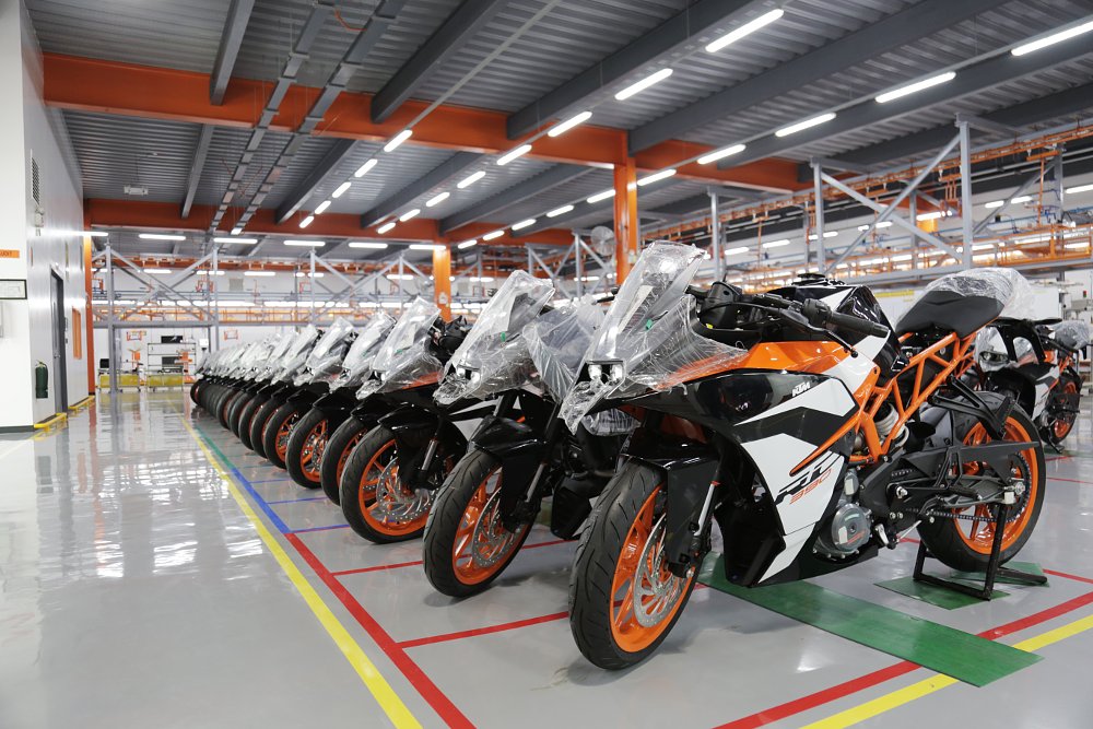Numerous KTM RC 390 sport bikes lined up in a production plant.