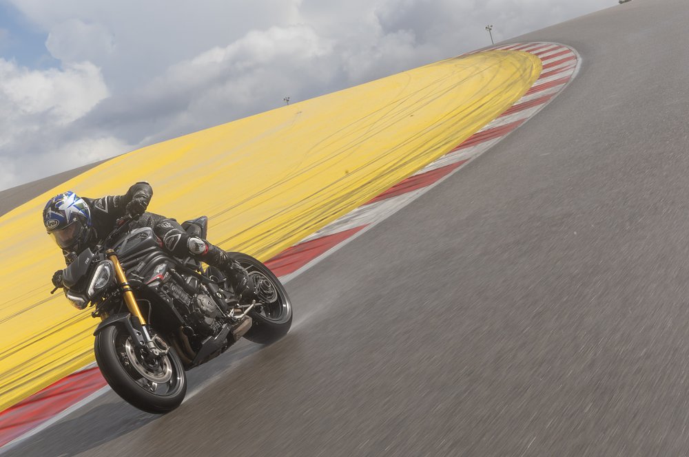 riding the Speed Triple on the track with sunlight lighting up the spray from the tires