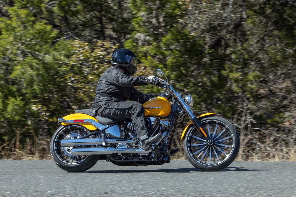 the author riding a yellow Harley-Davidson Breakout on a two-lane country road