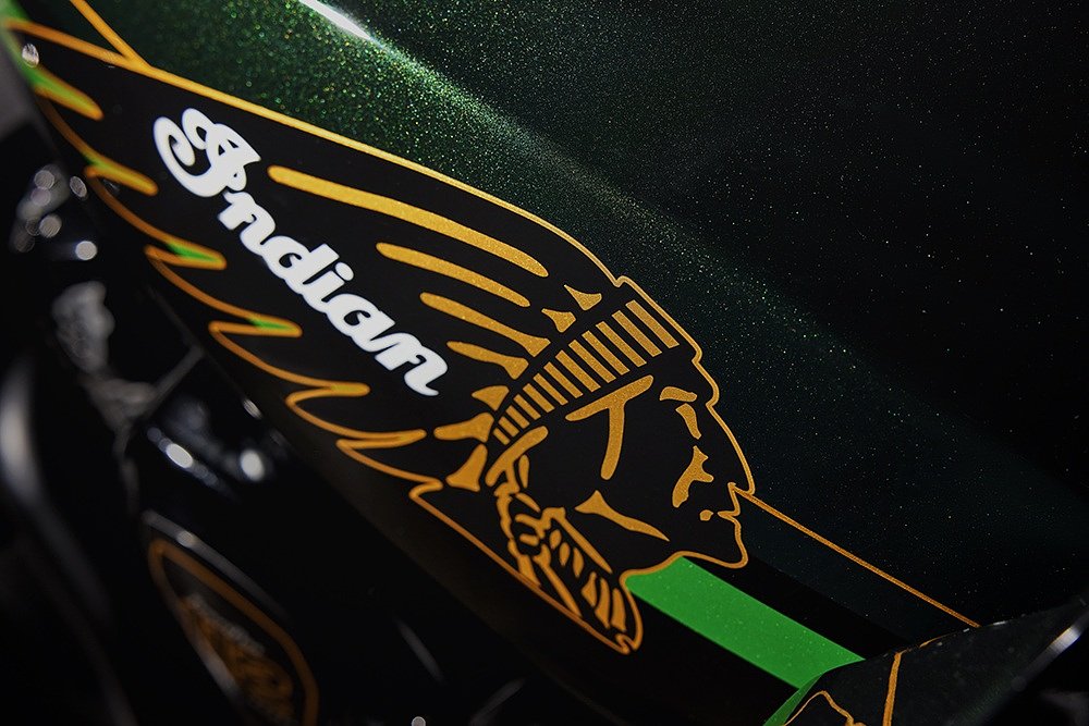 closeup studio shot of the gold Indian headdress logo on the black and green fuel tank of the Pursuit Elite