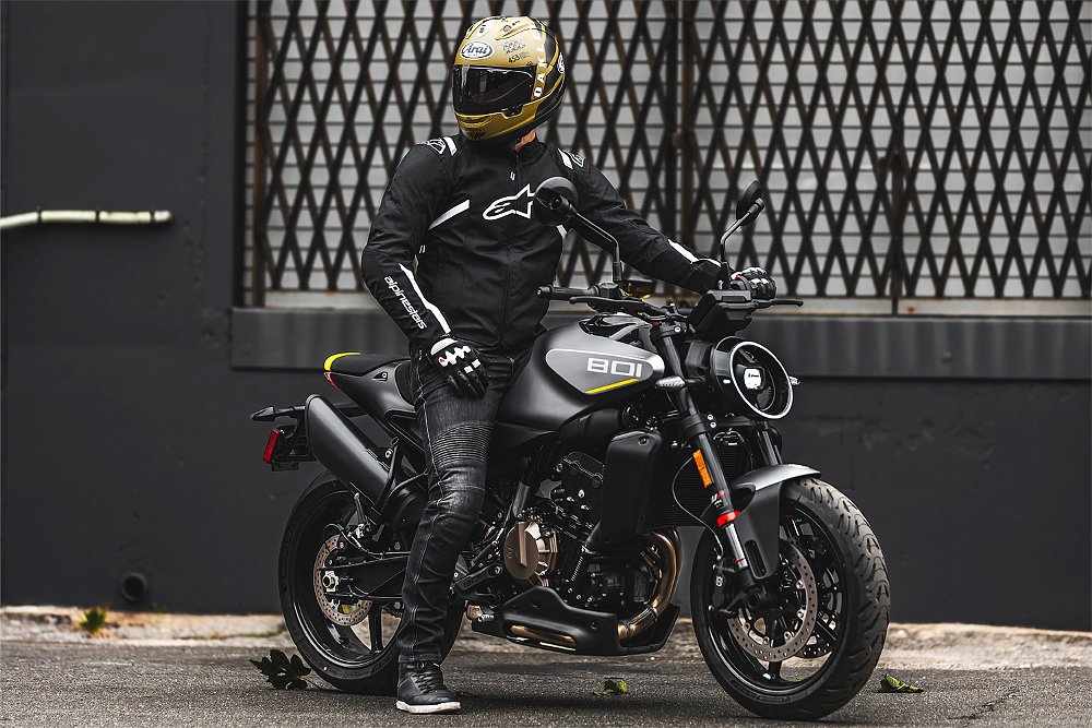 Dustin mounts the Vitpilen 801 with a shipping dock in the background.