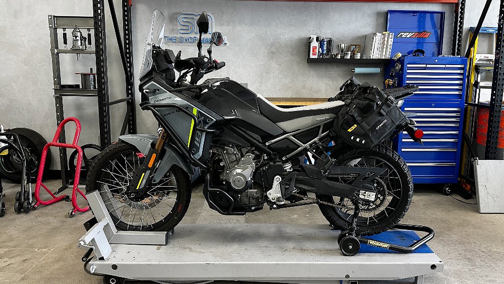 The fully-accessorized CFMOTO Ibex 450 project bike stands on the RevZilla West garage lift.