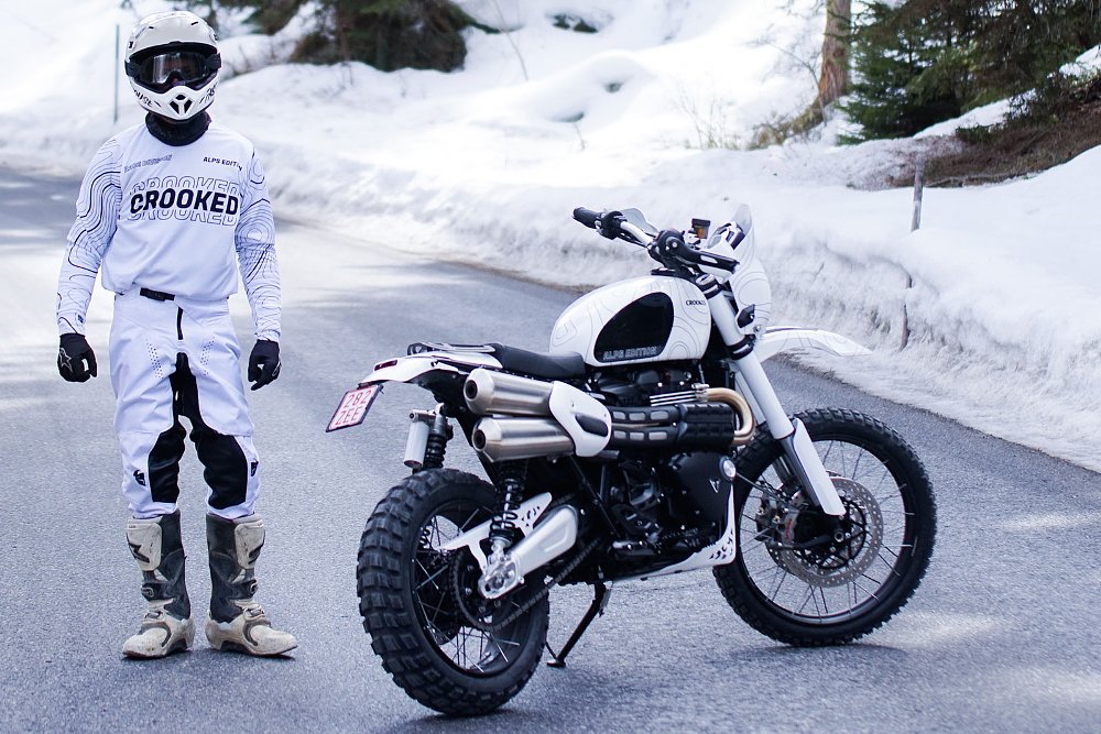 rider dressed in white standing beside the white custom in a snowy scene