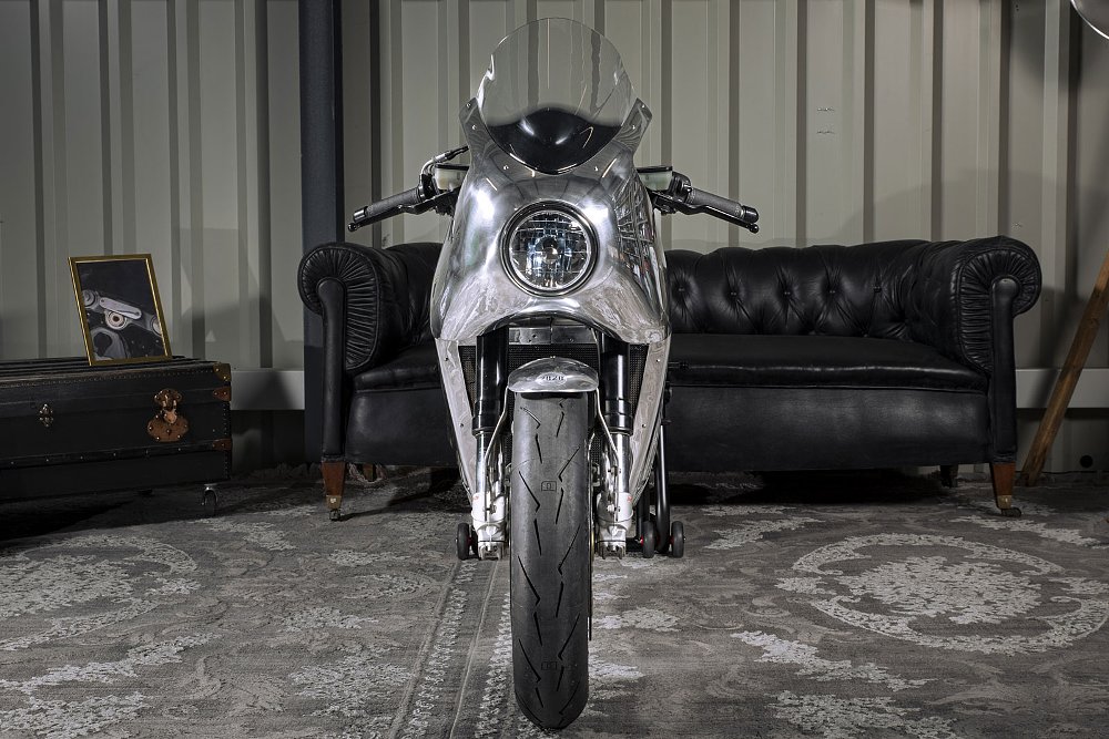 front view of the custom showing the round headlight in the bare aluminum bodywork