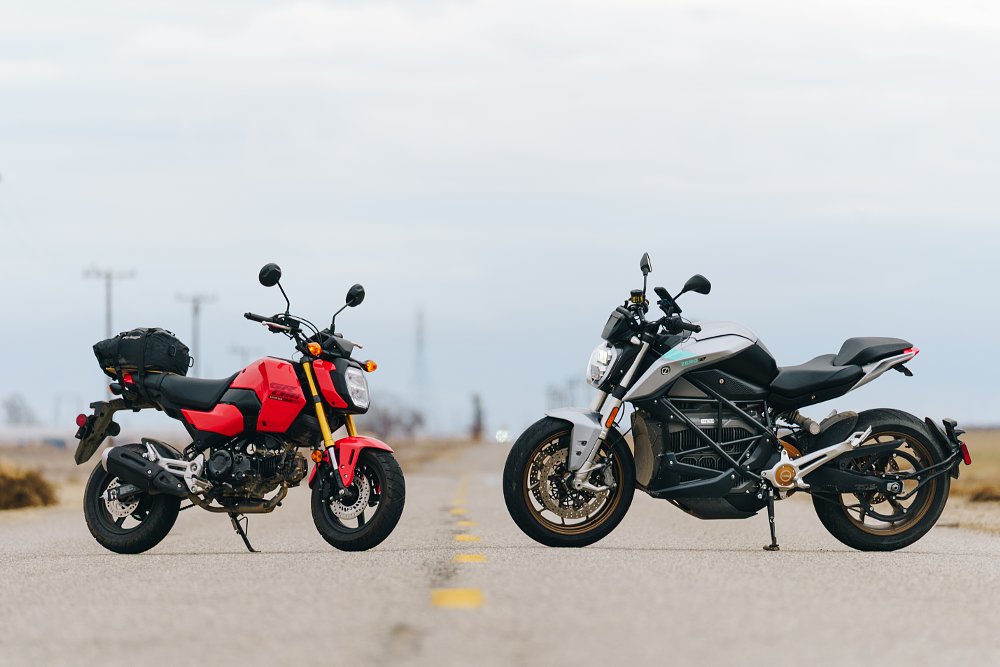 Honda Grom and Zero S parked on a desolate road.