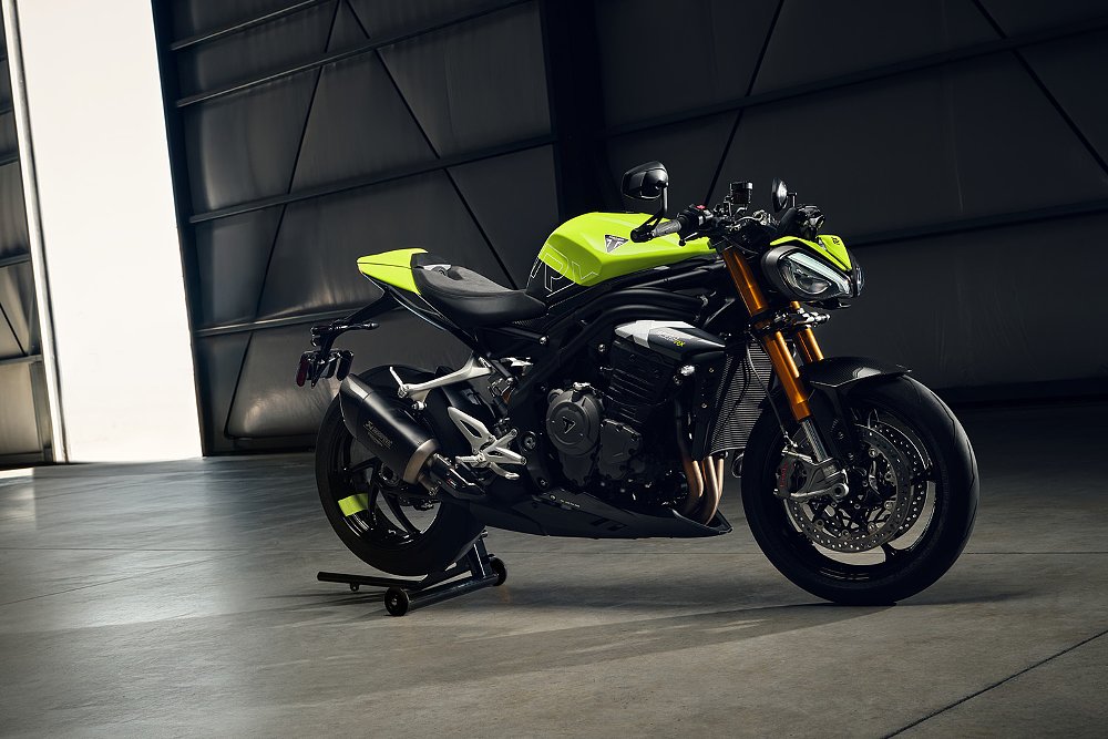 The Speed Triple 1200 RX staged in a dimly lit airplane hangar. 