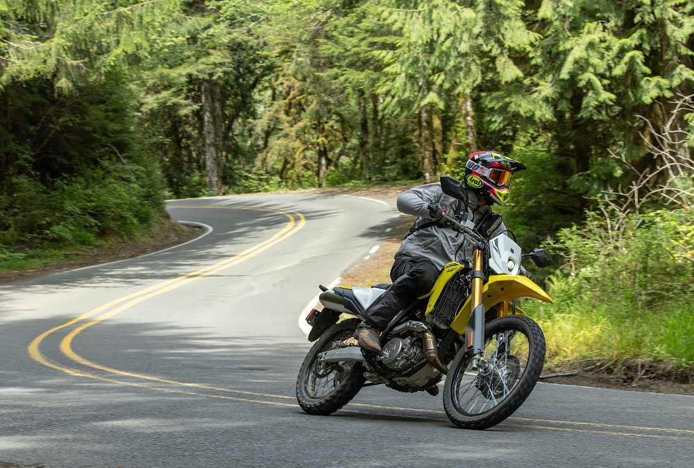 2025 Suzuki DR-Z4S riding along a twisty paved road.