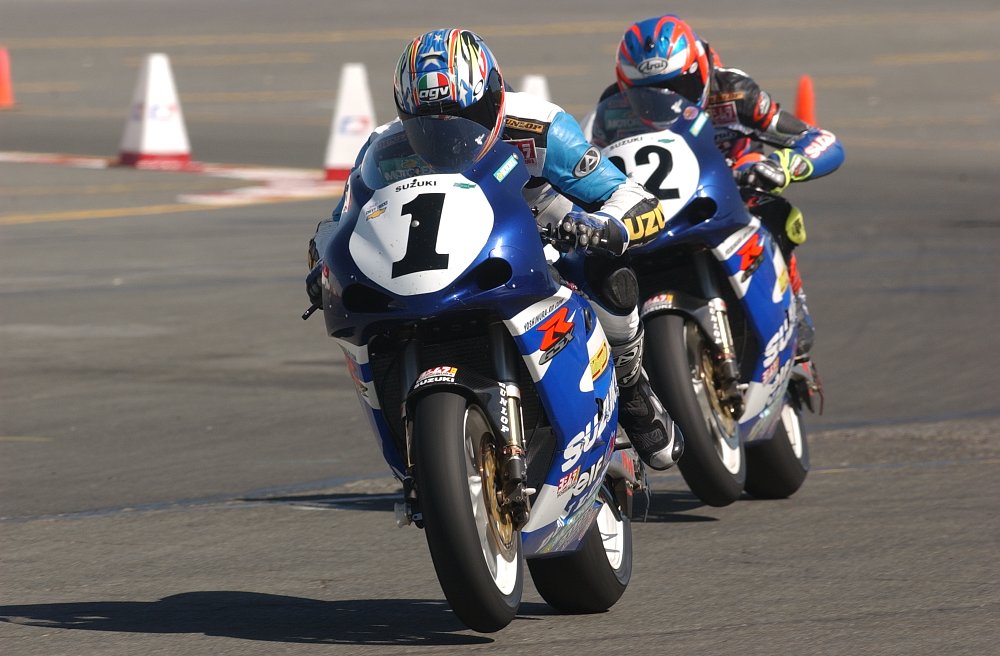 Mladin on his blue and white Yoshimura Suzuki GSX-R1000 race bike leads his teammate on an identical machine in a race