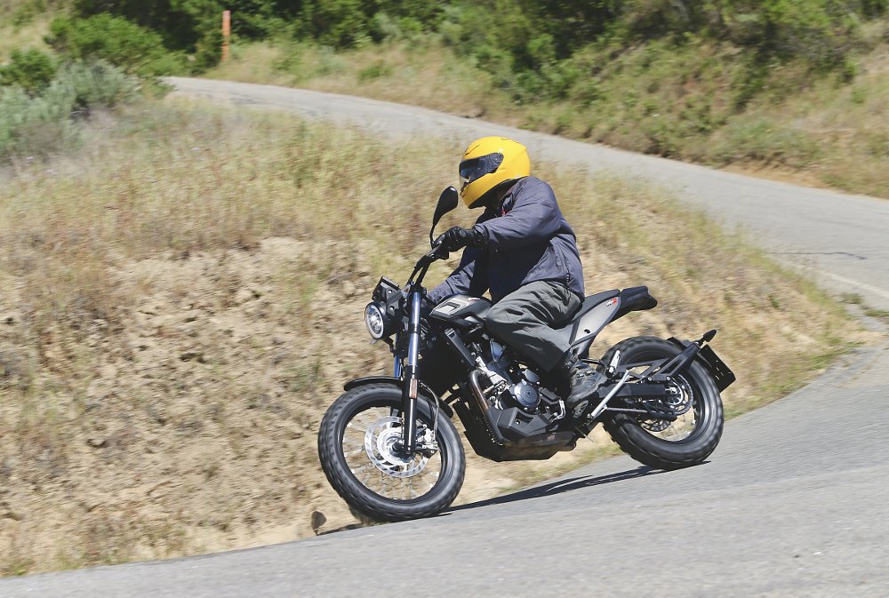 riding the Beta Alp X through a curve on a paved road