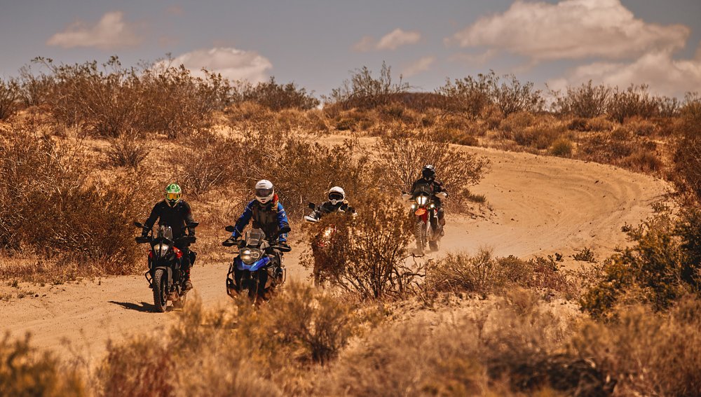 group of riders on a remote and dusty dirt lane