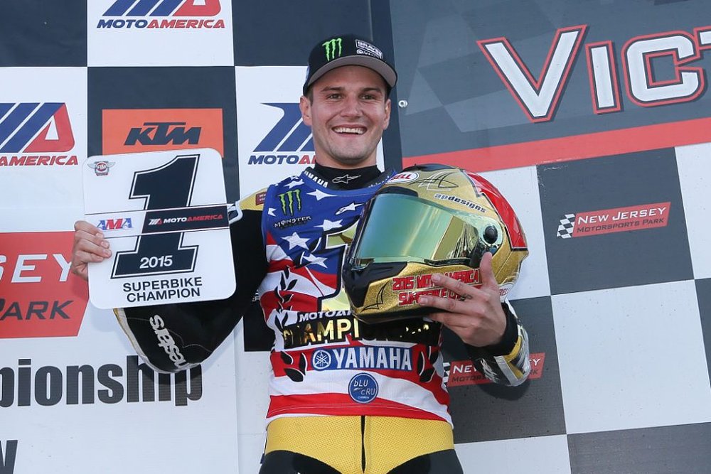 a smiling Cameron Beaubier holding the 2015 #1 plate after winning his first Superbike championship